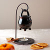 Burner di profumo appeso alla caldaia nera con supporto
